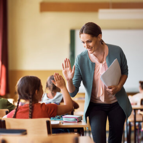 student and teacher high fiving